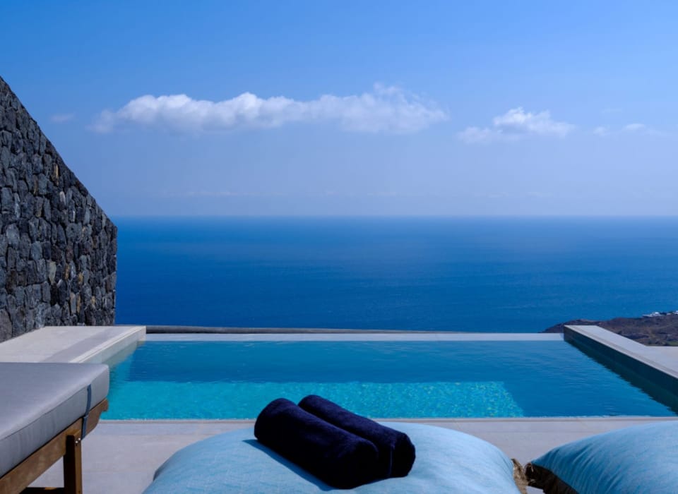 a pool with a rock wall and a blue sky