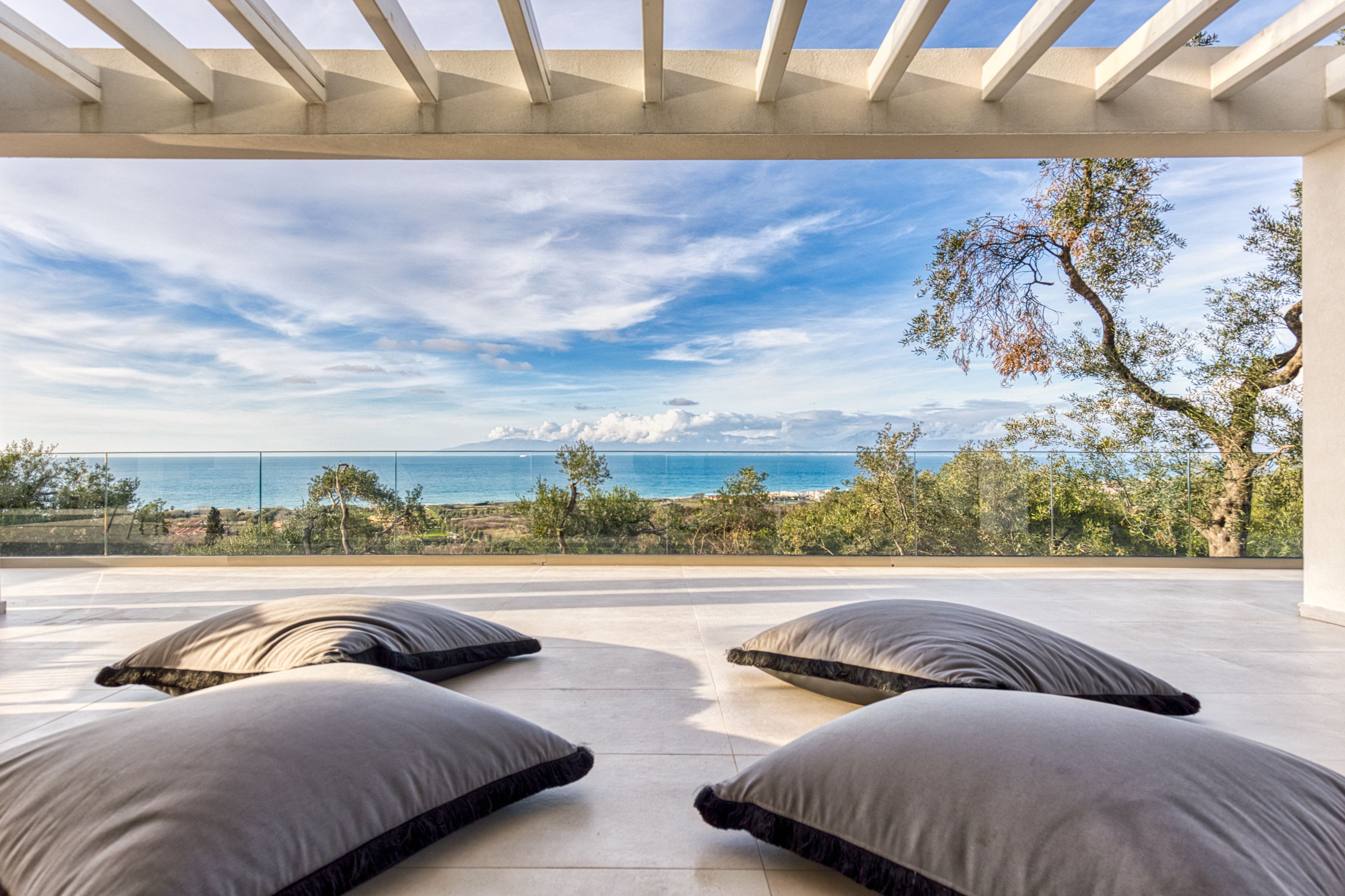 a deck with a view of the ocean and trees