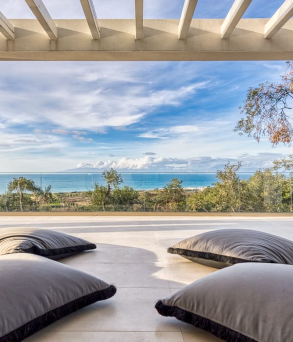 a deck with a view of the ocean and trees