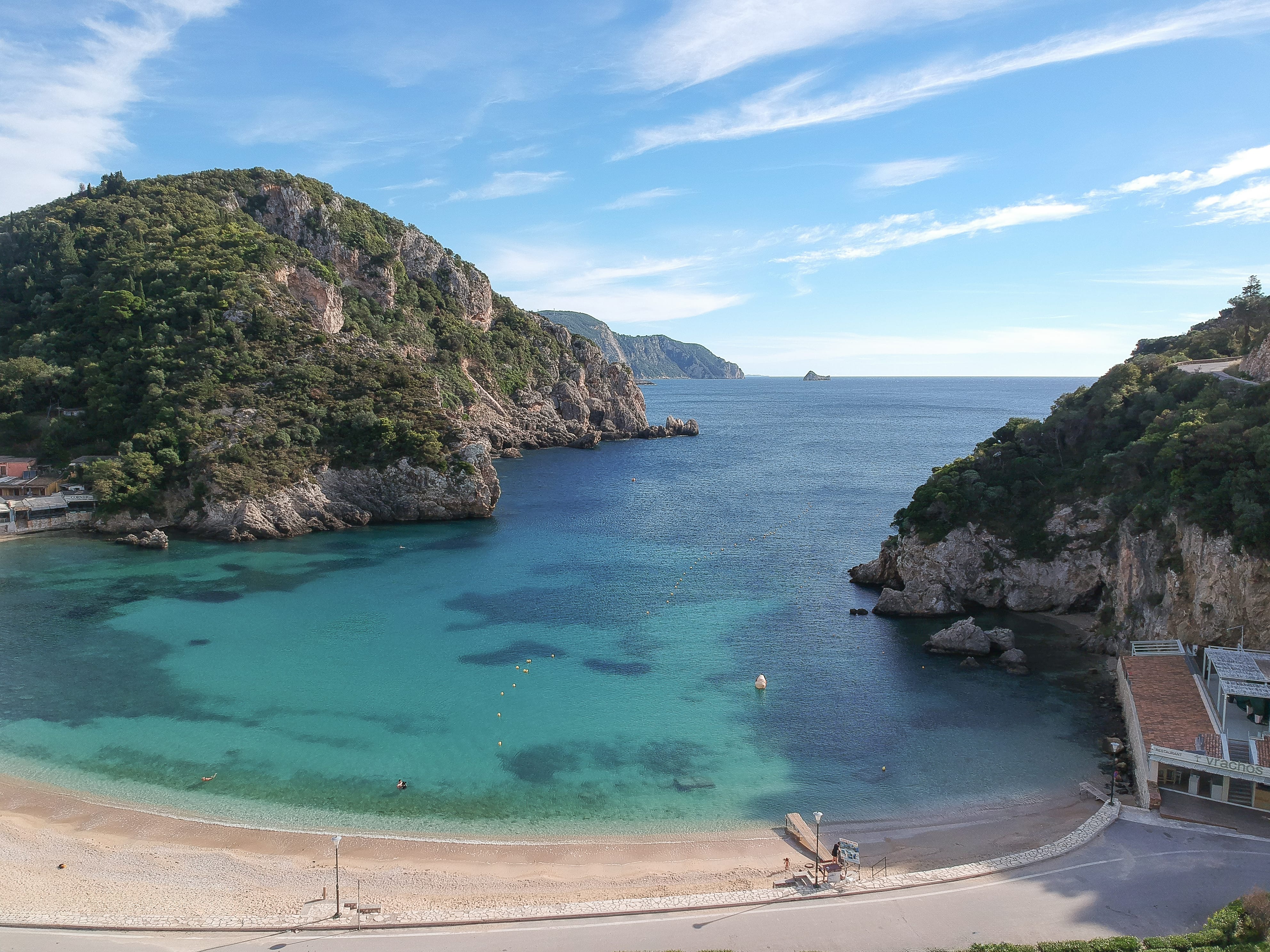 a beach with a body of water and a rocky cliff