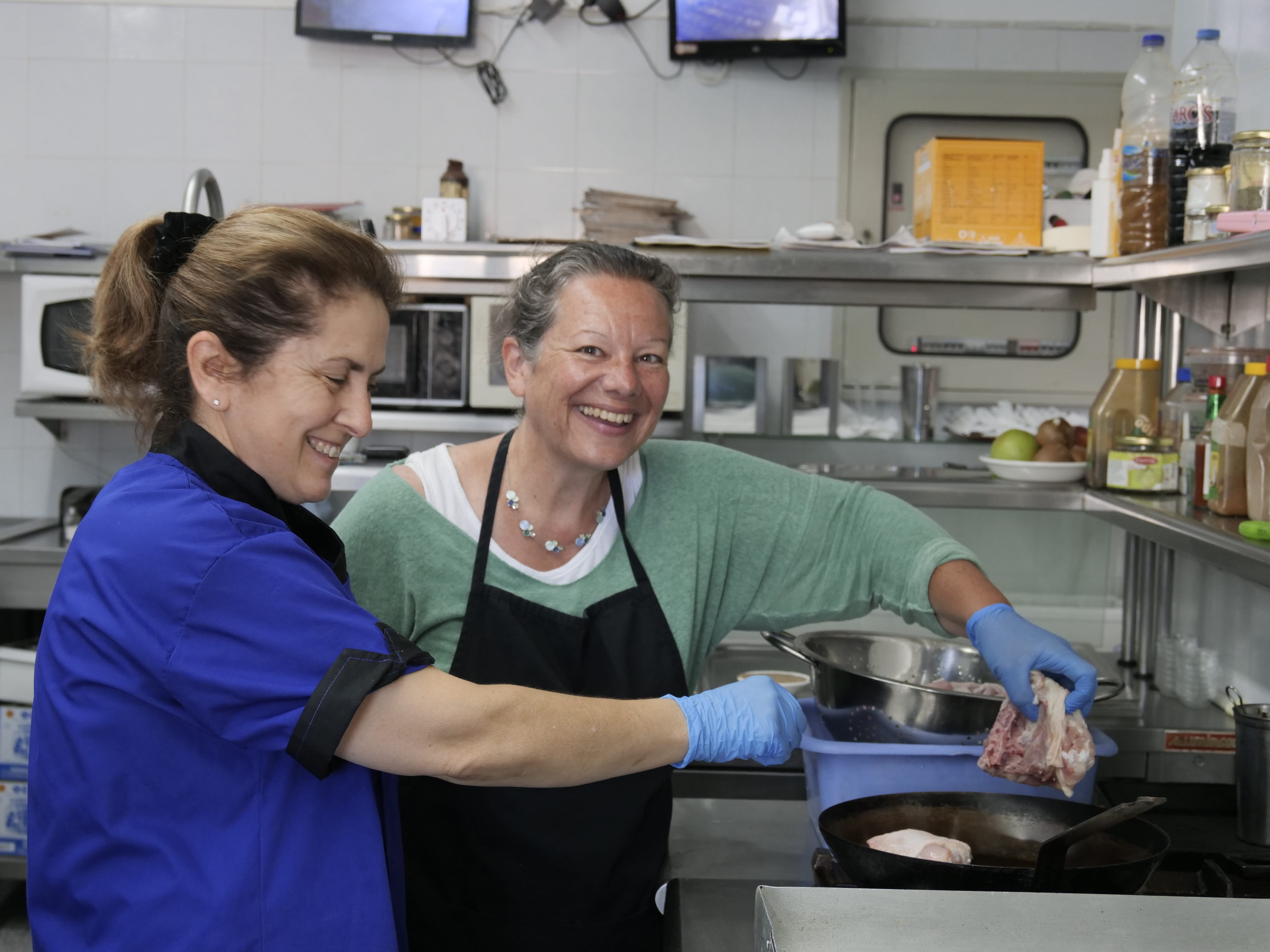 a woman and a man cooking in a kitchen