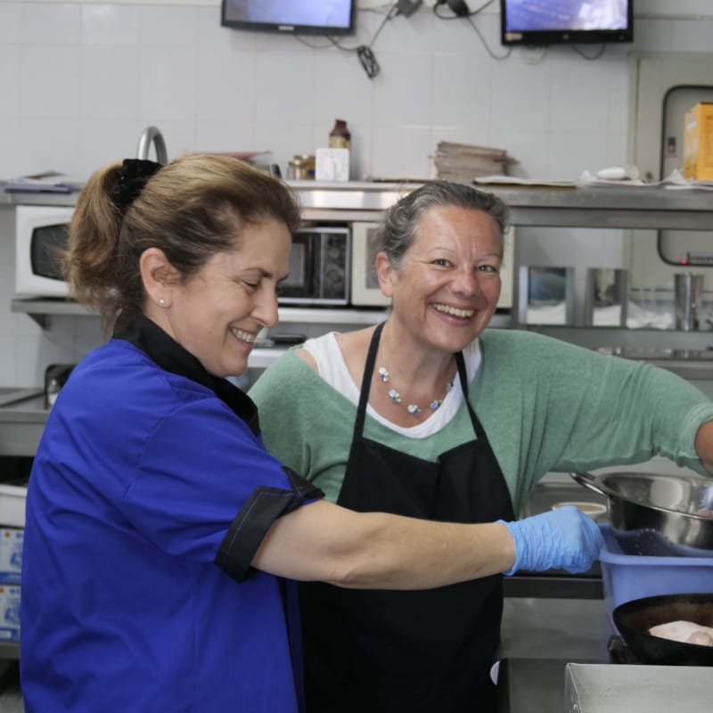 a woman and a man cooking in a kitchen