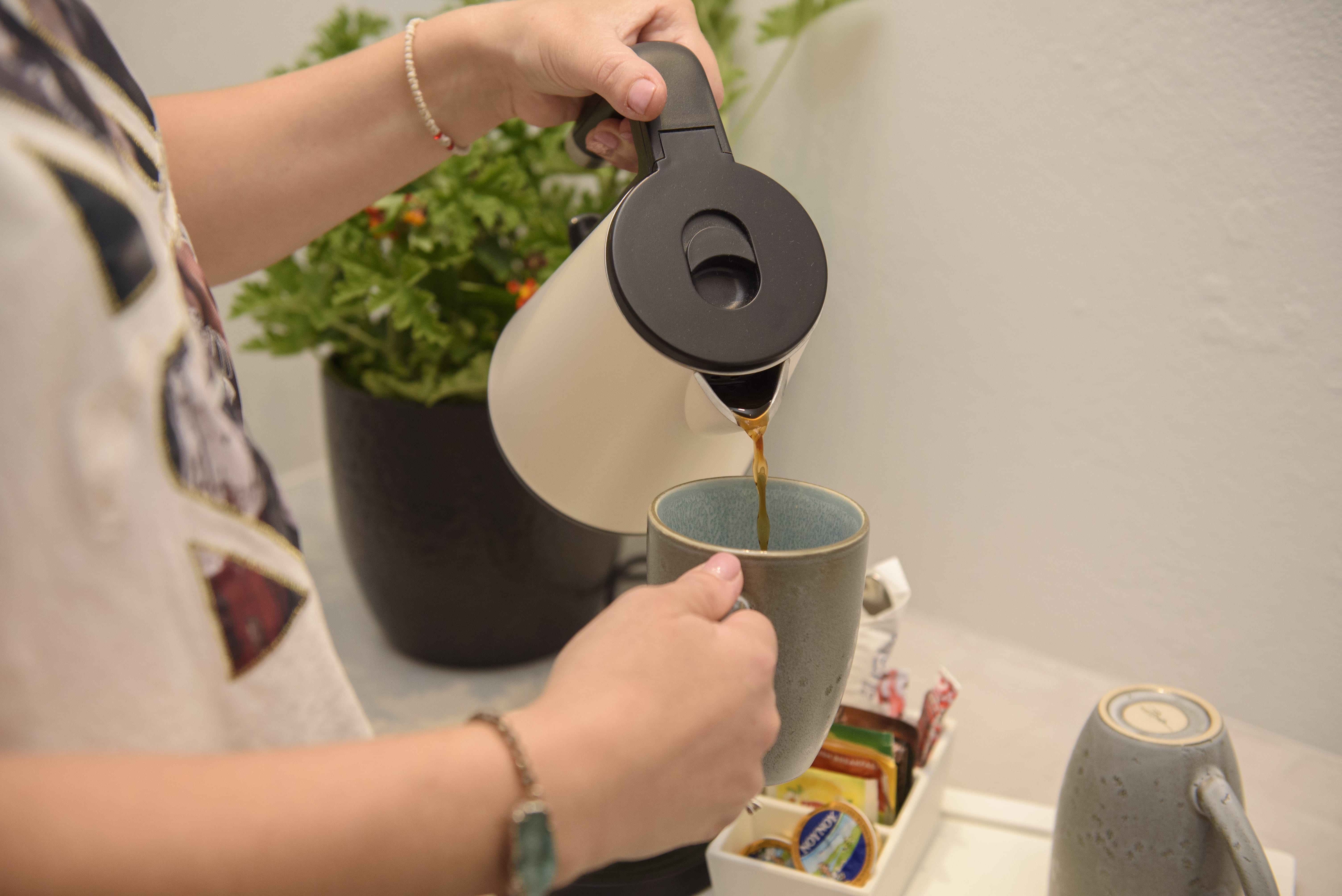 a person pouring a liquid into a cup