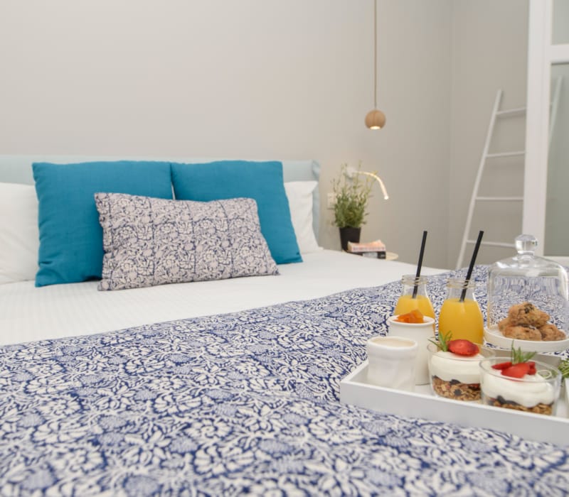 a bed with a white bed spread and a blue pillow