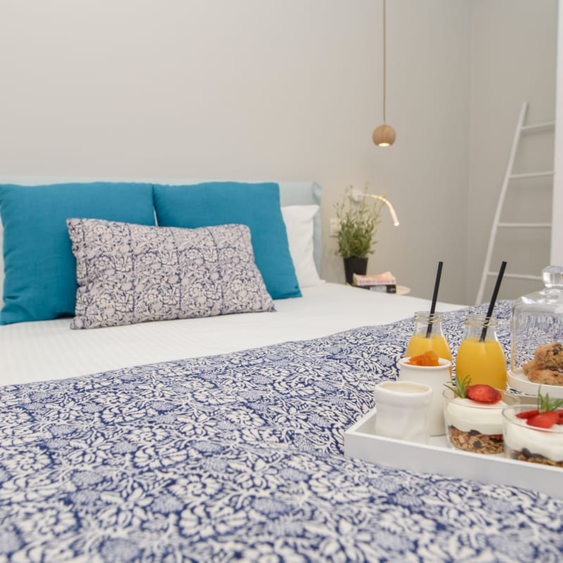 a bed with a white bed spread and a blue pillow