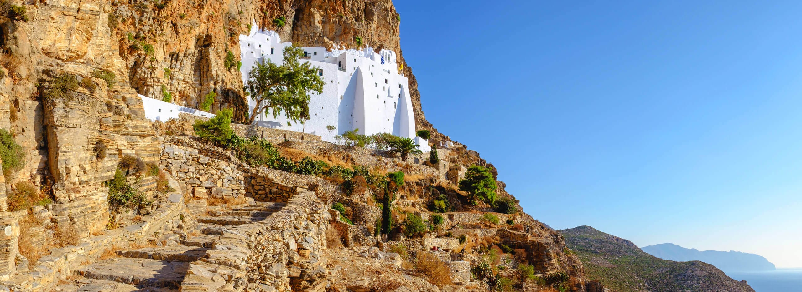 a rocky cliff with a few buildings