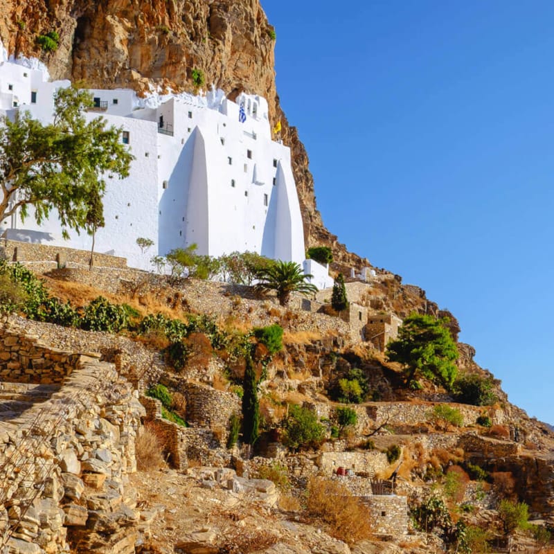 a rocky cliff with a few buildings