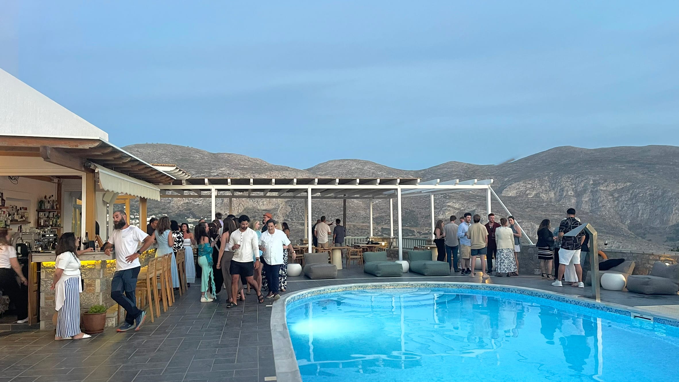 a group of people standing around a pool