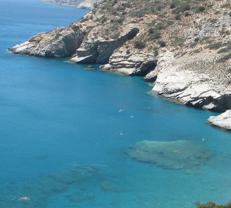 a body of water with rocks and a beach