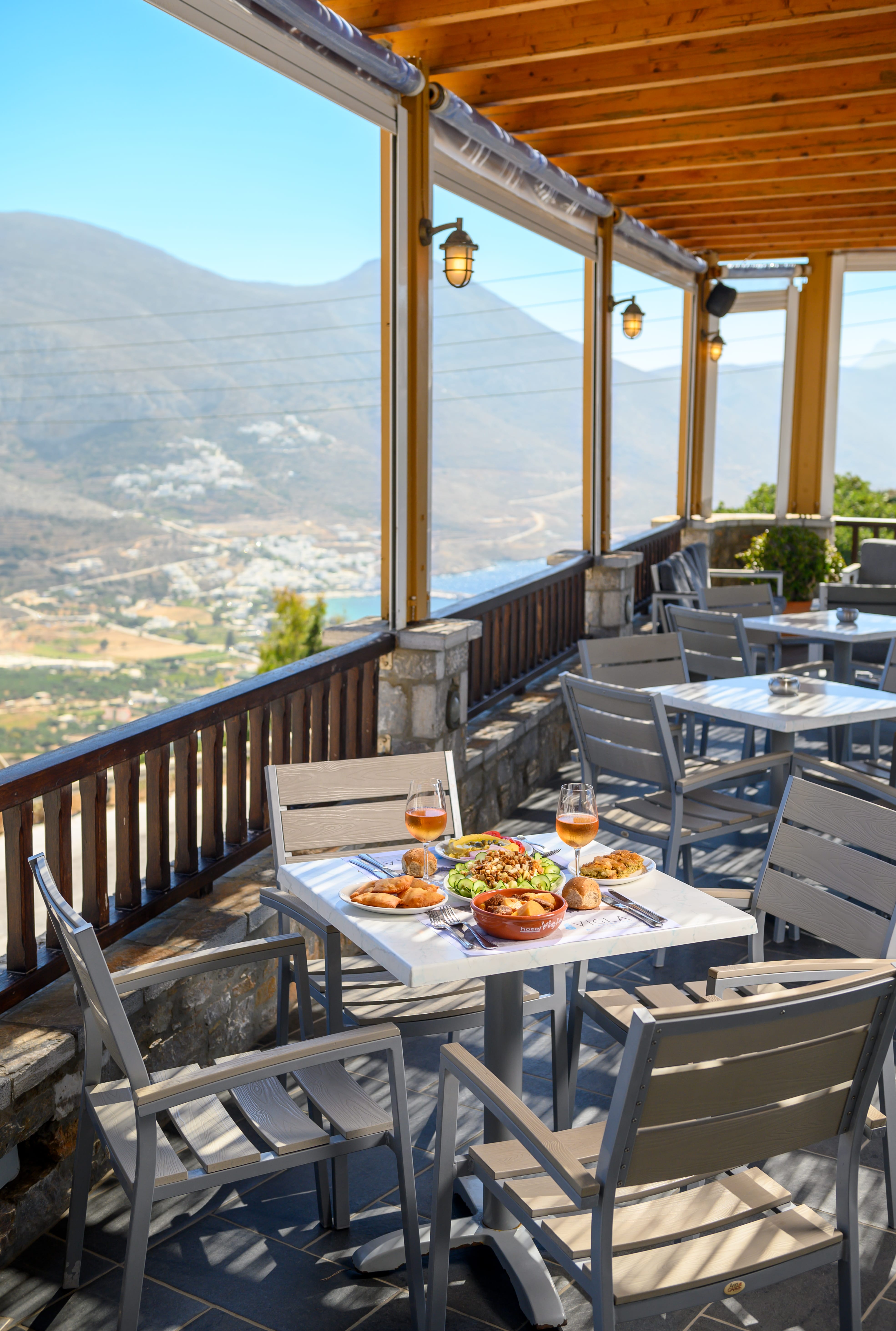 a table with food on it on a deck with a view of a valley and mountains