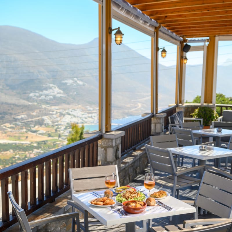 a table with food on it on a deck with a view of a valley and mountains
