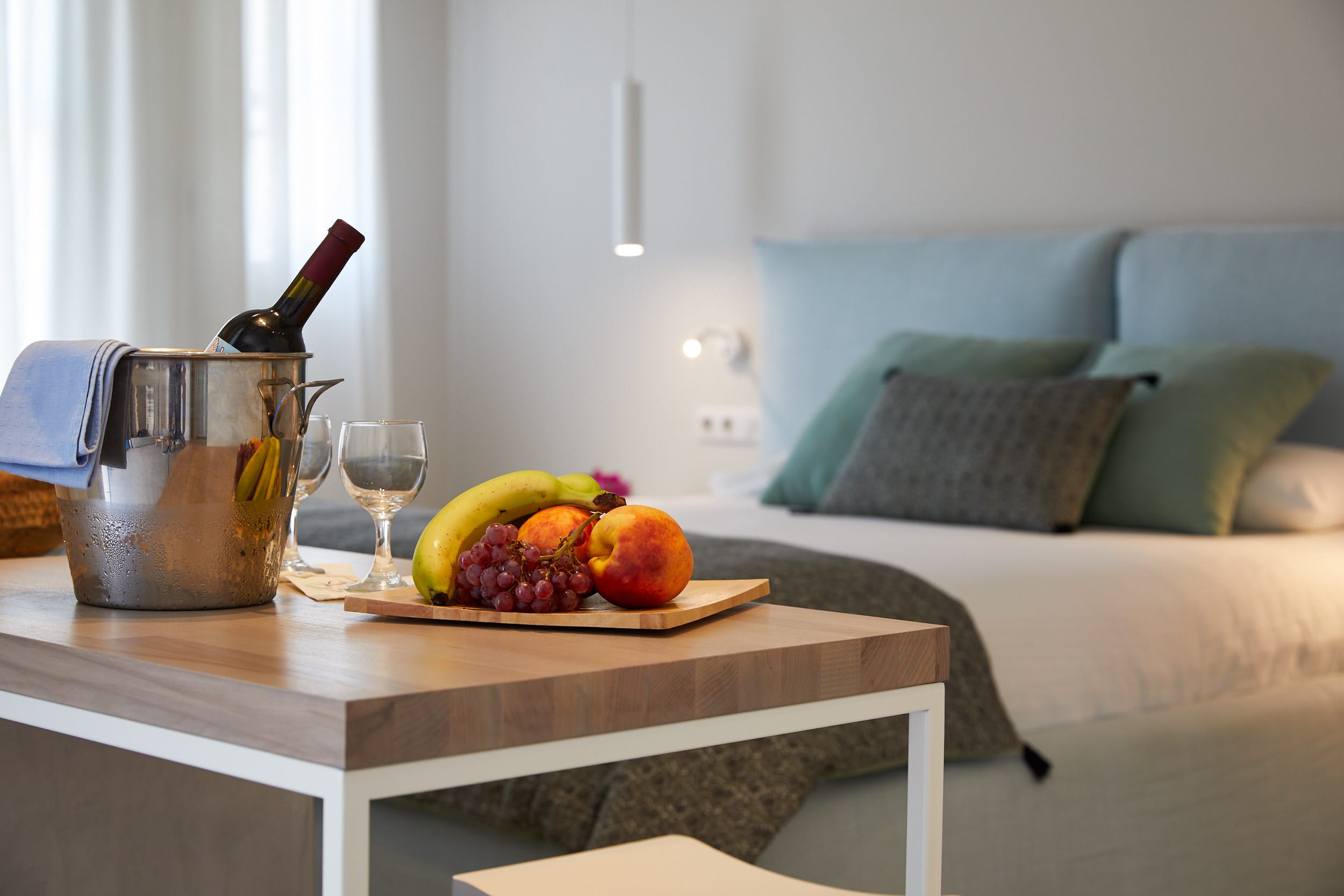a table with a bowl of fruit and a glass of wine