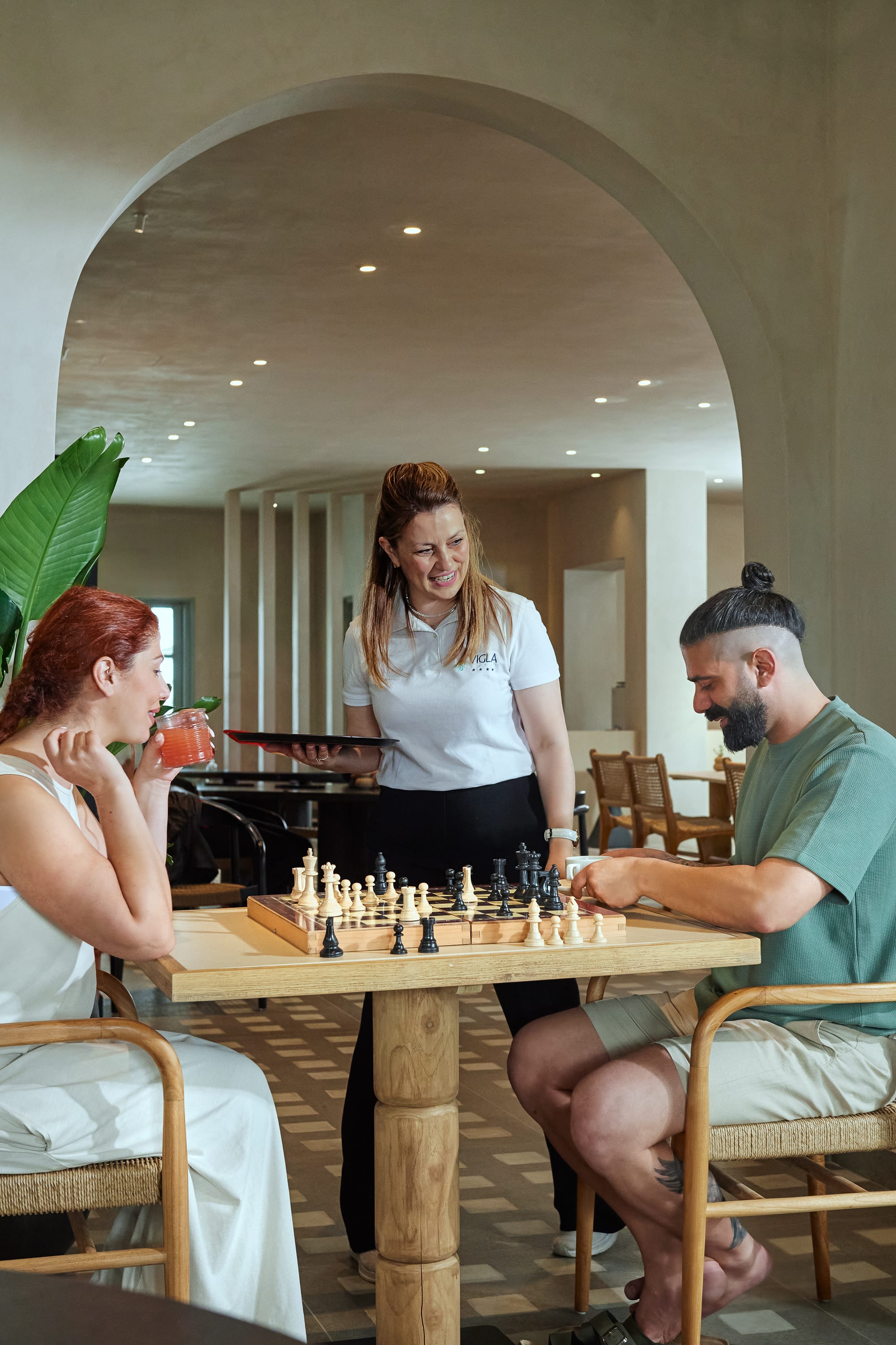 a person standing next to a person playing chess