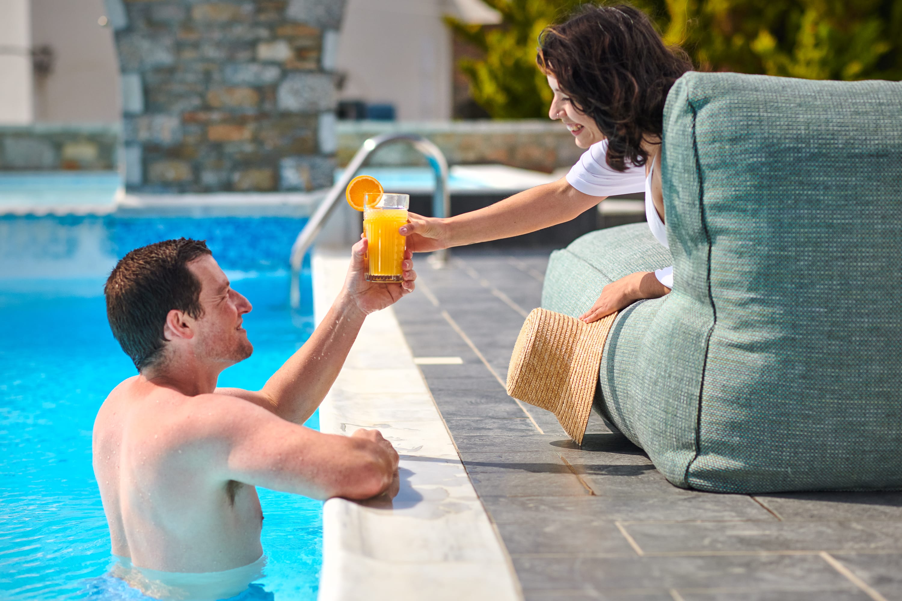 a person and person sitting by a pool