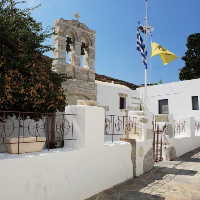 a stone wall with a statue and flags on it