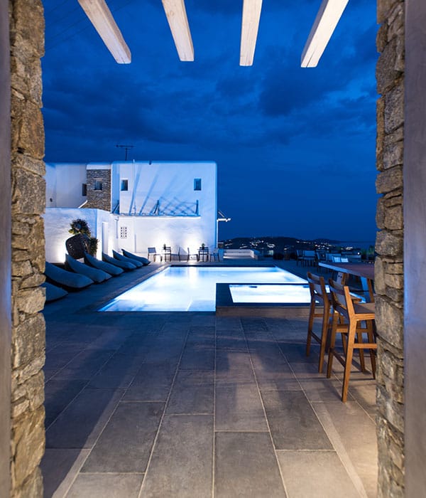 a person sitting on a couch next to a pool