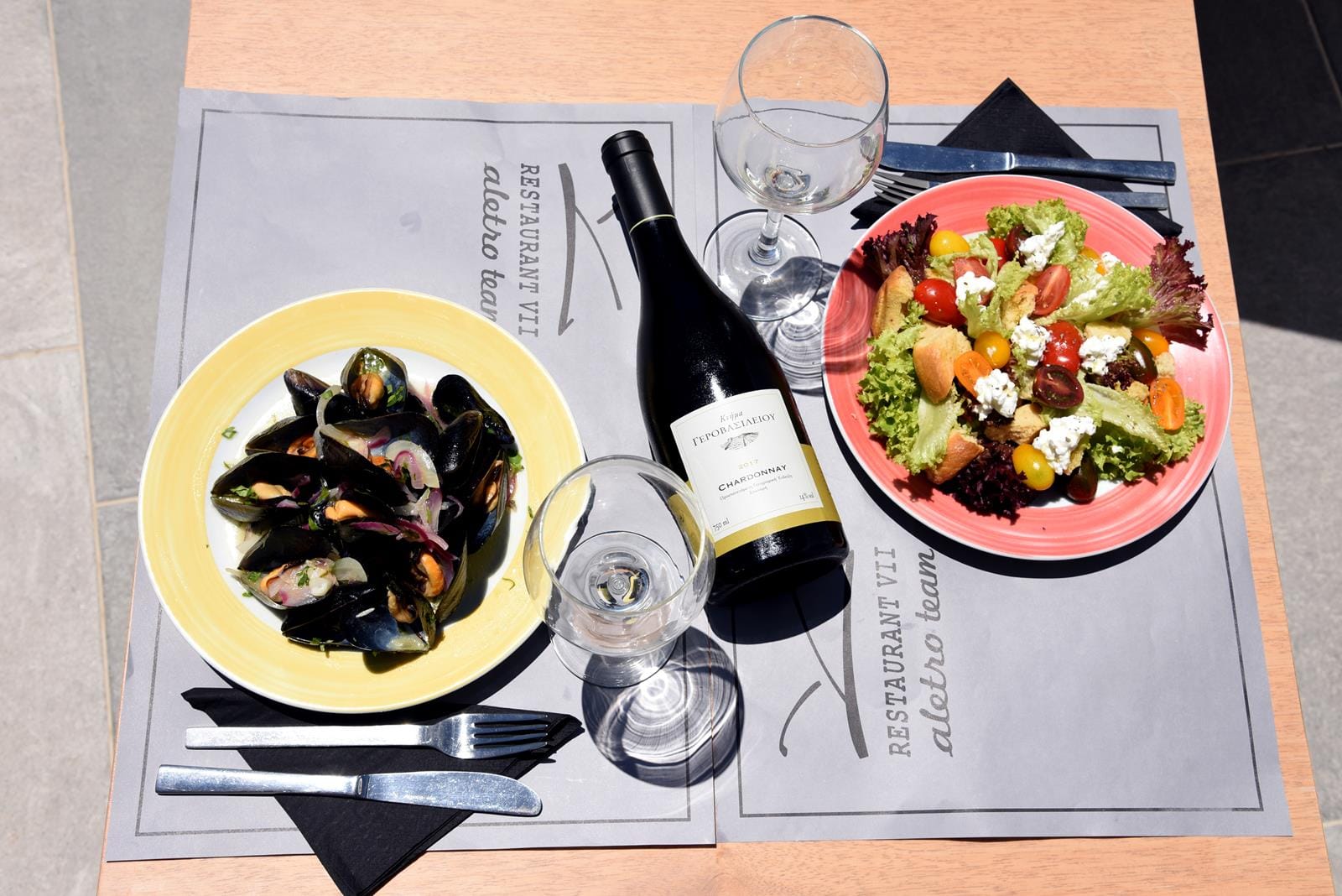 wine glasses and salad on a table