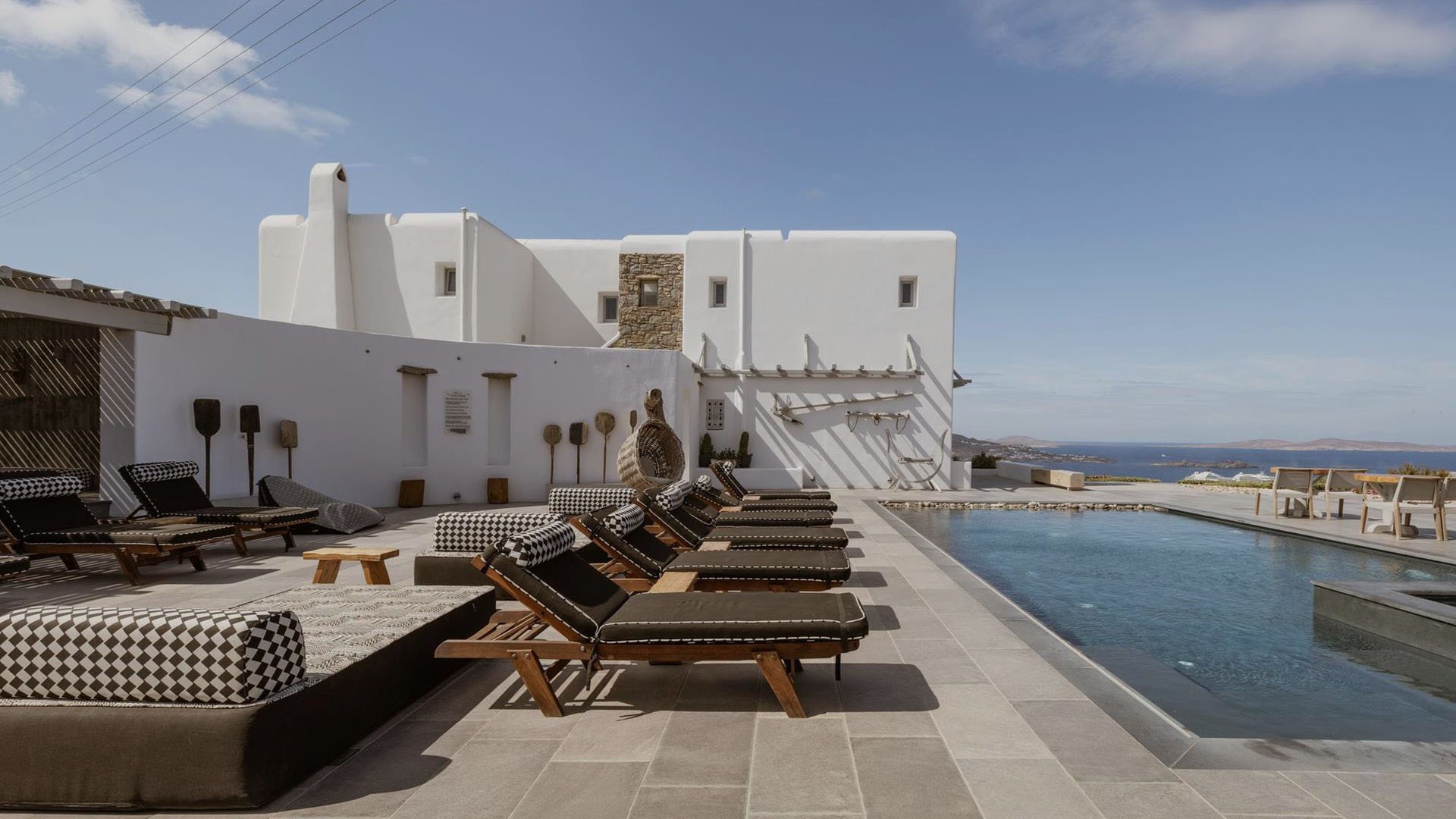 a building with tables and chairs by the water