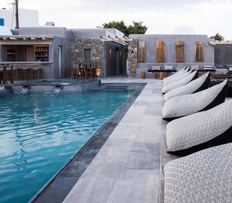 a pool with a deck and chairs by it