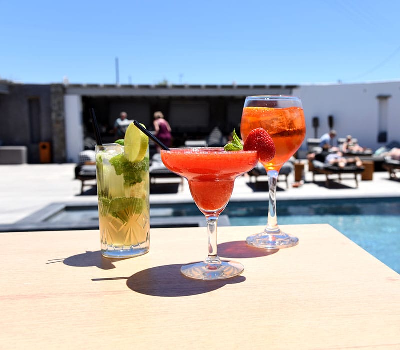 a couple of glasses with colorful drinks