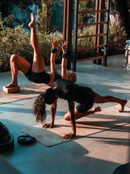 two women doing yoga on a mat