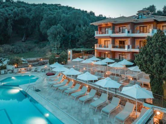 a pool with umbrellas and chairs next to a building