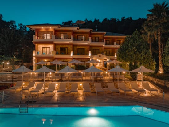 a large house with a pool and lounge chairs around it