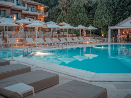 a pool with a lounge chair and umbrellas next to it