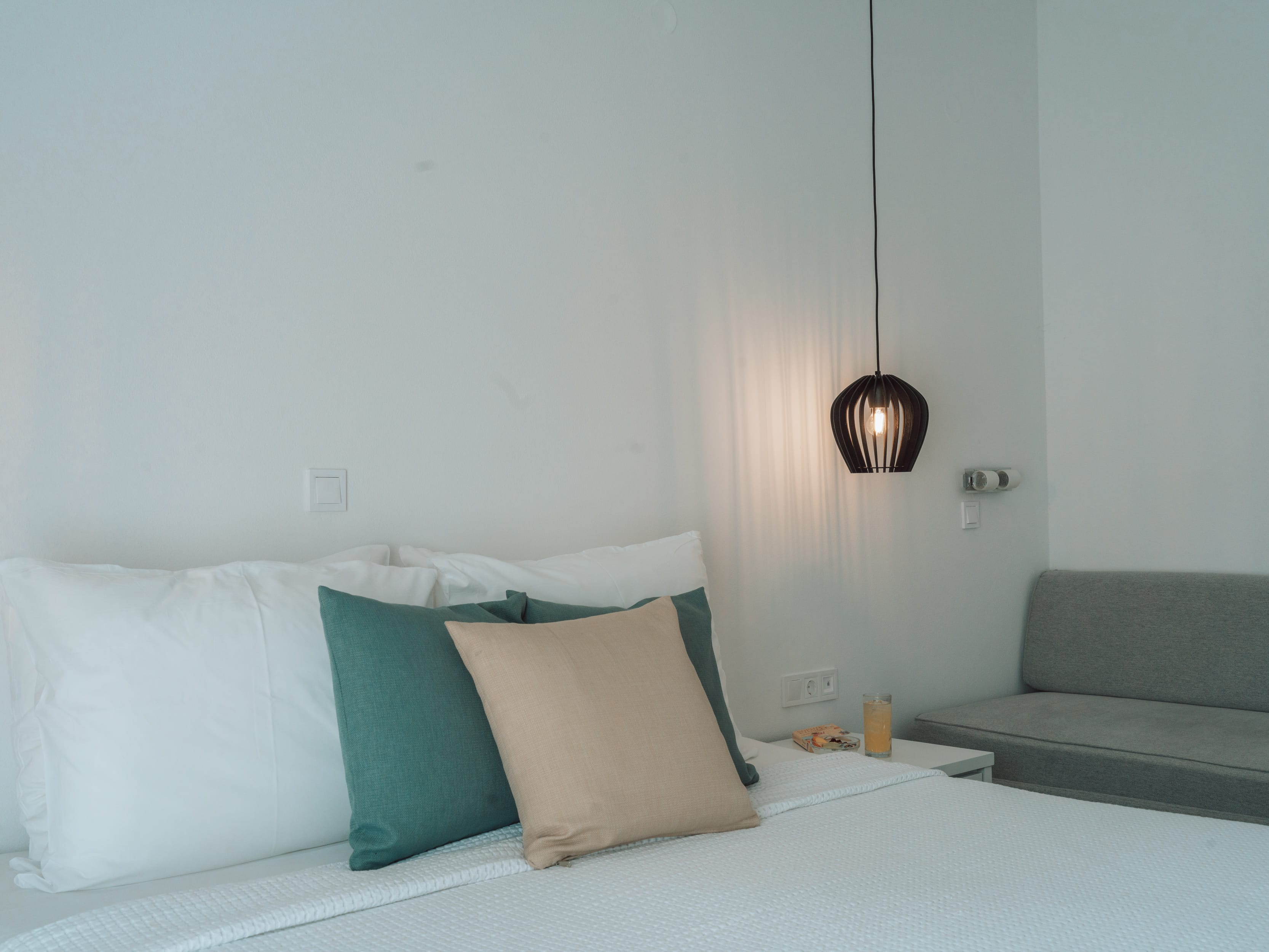 a bed with a lamp on the wall