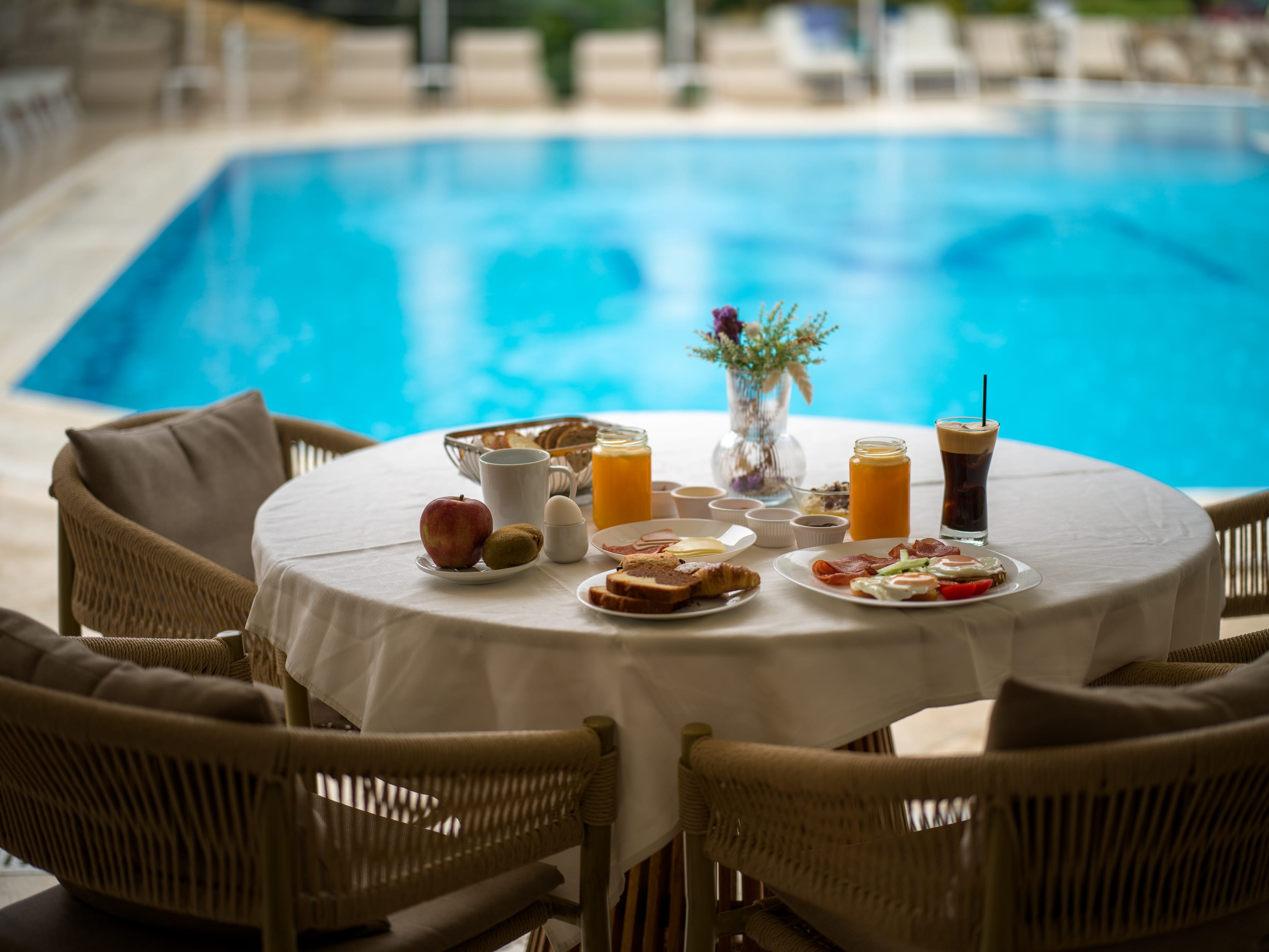 a table with food and drinks by a pool