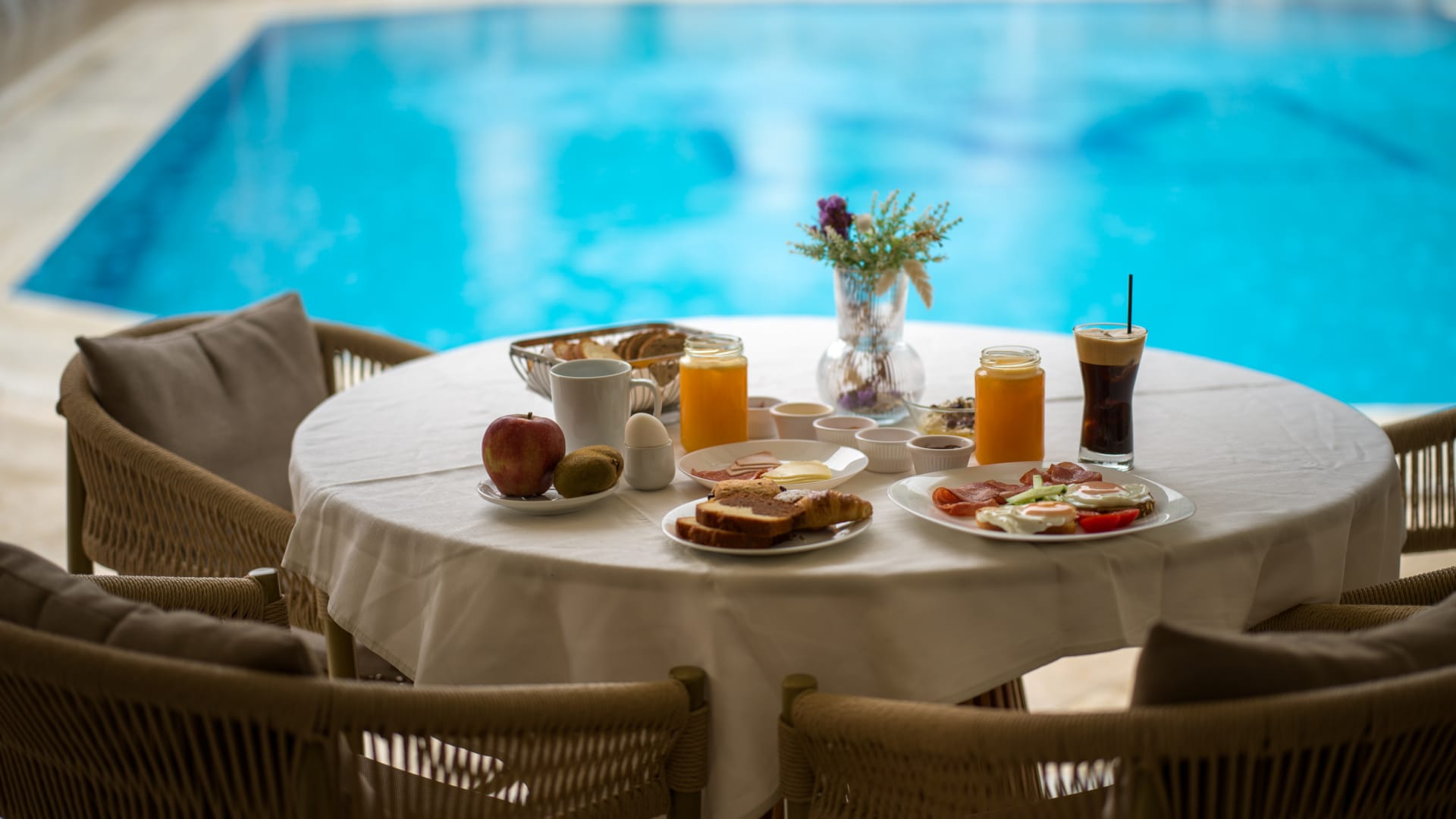 a table with food and drinks by a pool