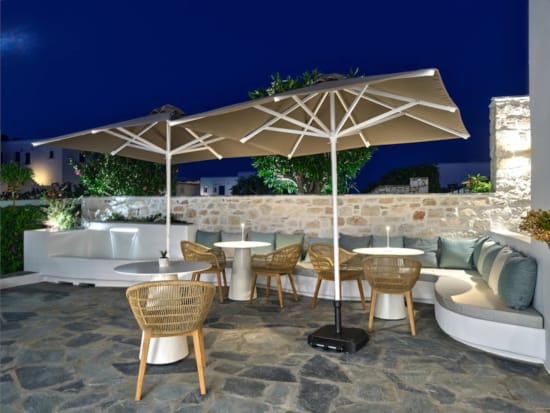 πλακόστρωτη αυλή με τραπέζια και καρέκλες