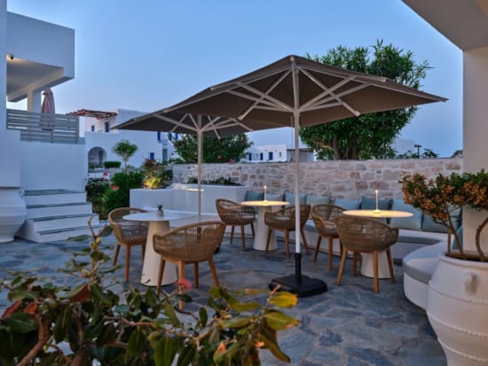 πλακόστρωτη αυλή με τραπέζια και καρέκλες