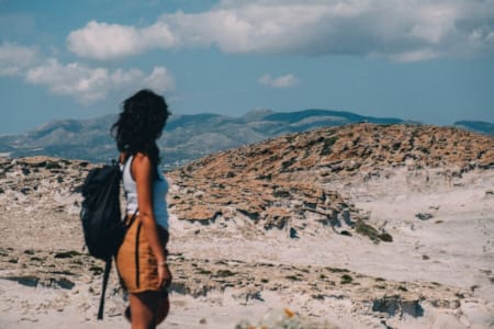 a person with a backpack walking on a rocky terrain