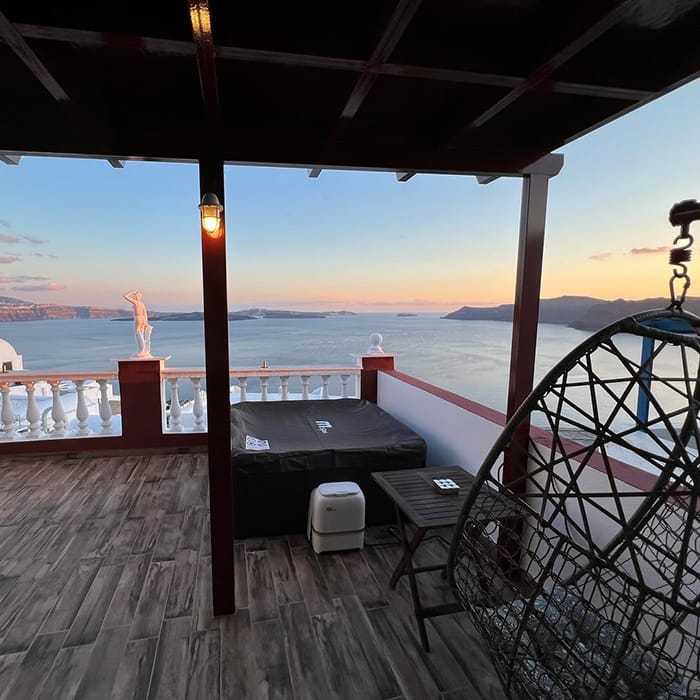a deck with a railing and a body of water in the background