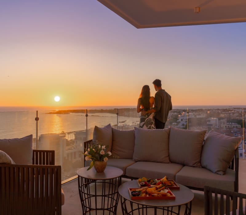 a couple of people standing on a balcony overlooking the ocean