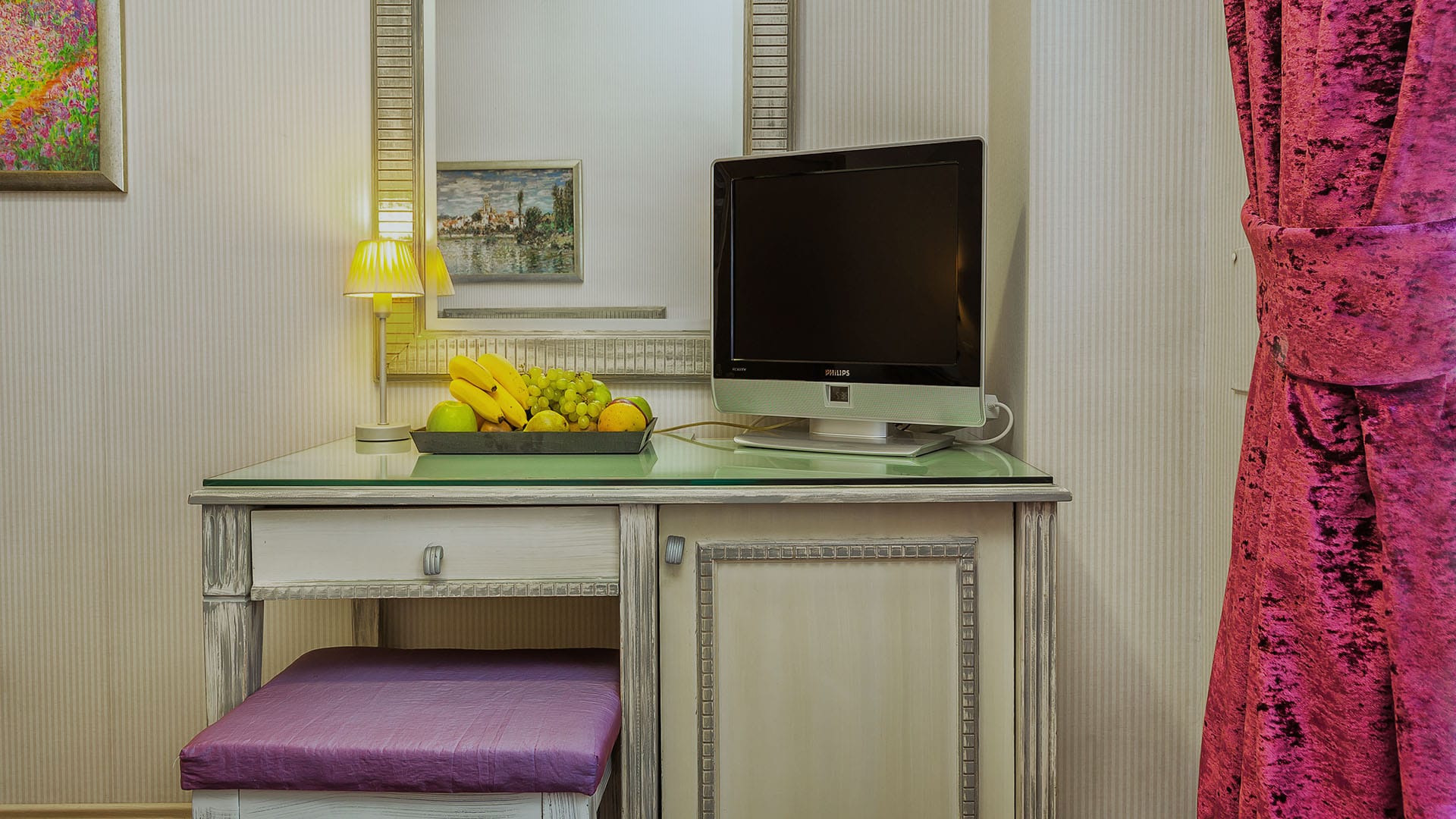 a desk with a computer and a lamp on it