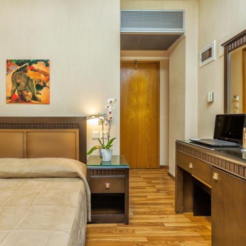 a bedroom with a laptop on a desk