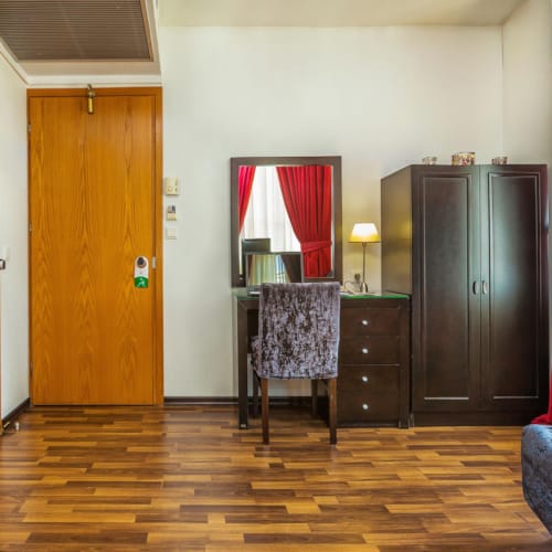 a room with a wood floor and a wood floor with a black cabinet and a red curtain
