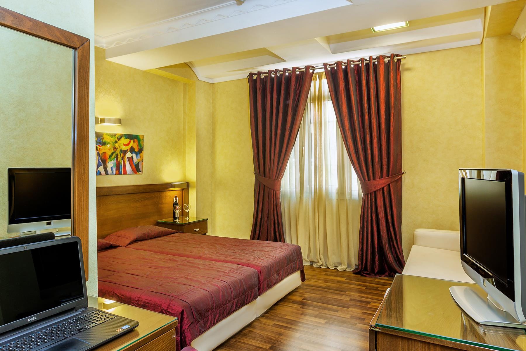 a bedroom with a bed and a laptop