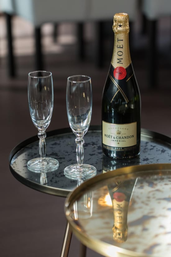 a bottle of wine and two empty wine glasses on a table