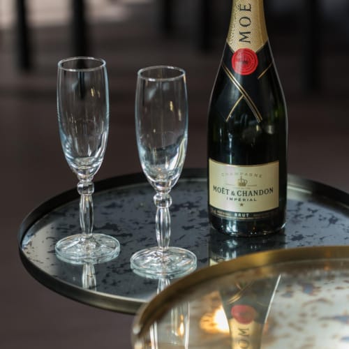 a bottle of wine and two empty wine glasses on a table