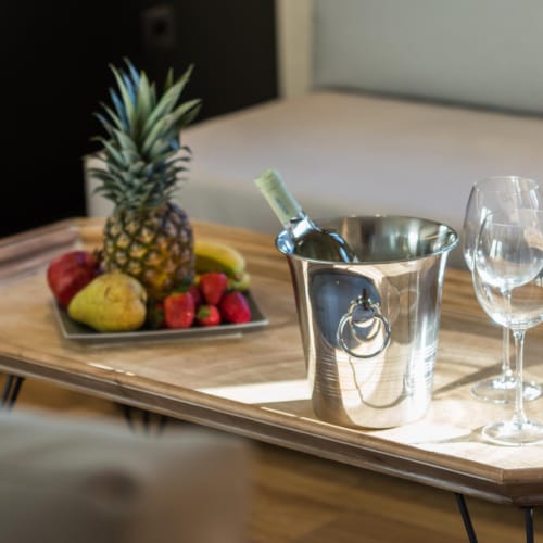 a table with a glass and a plate of fruit
