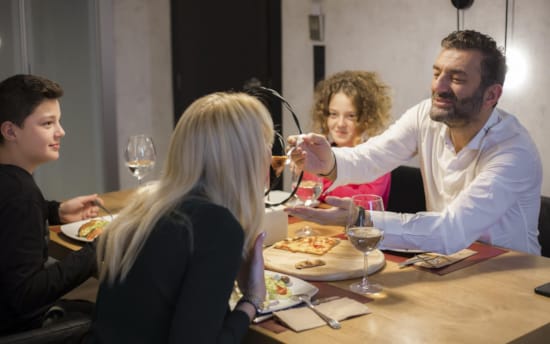 a group of people sitting around a table eating food