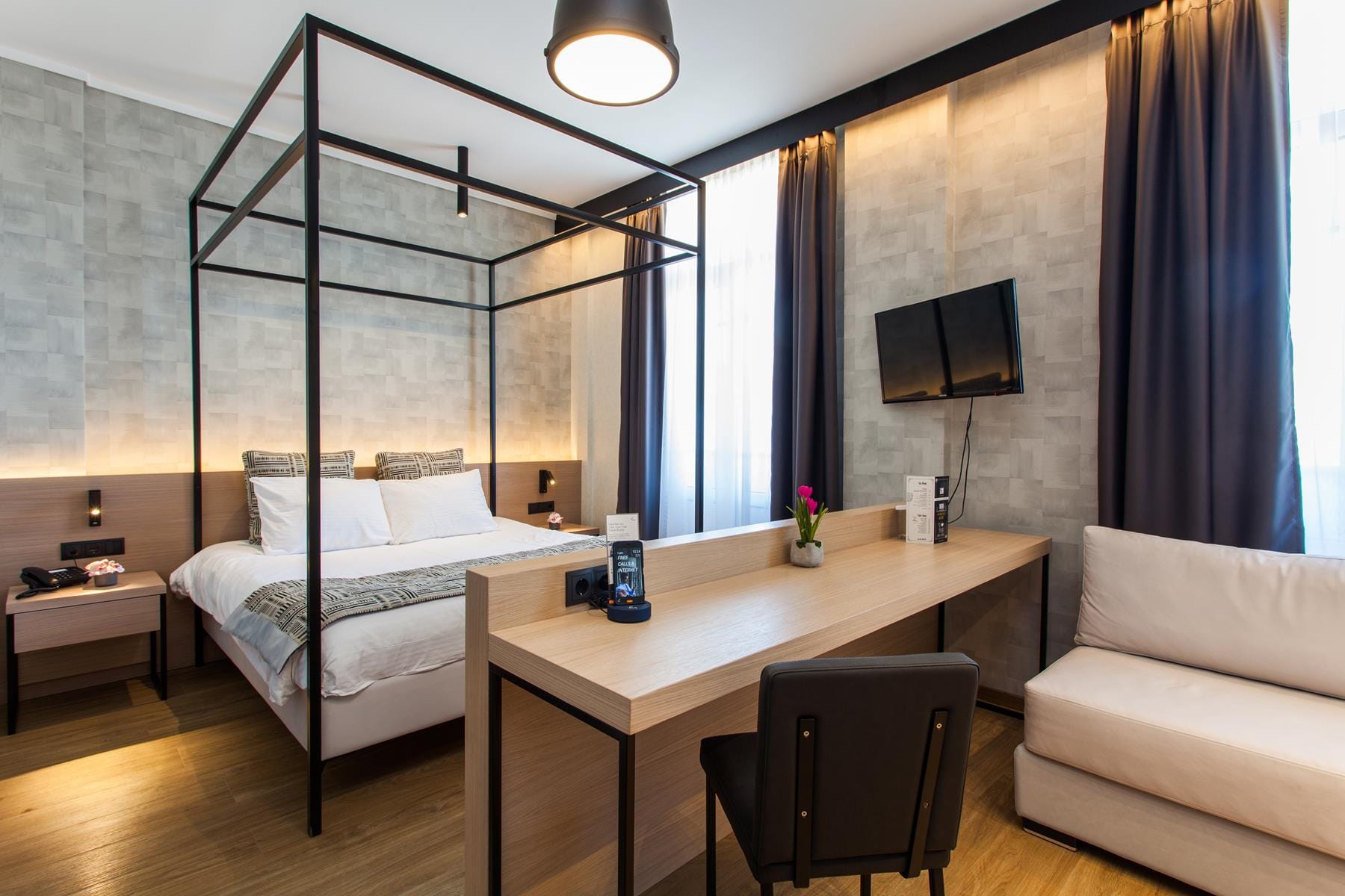 a bedroom with a bed desk and a tv