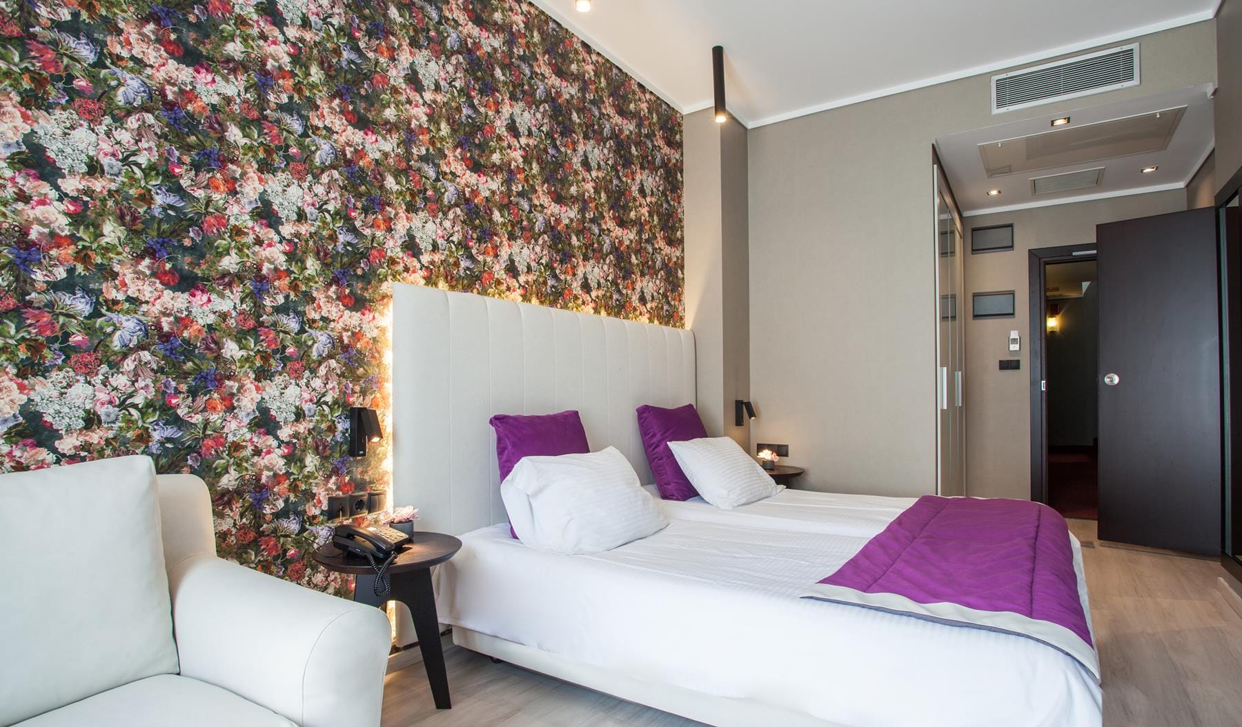 a bed with a flowered wallpaper