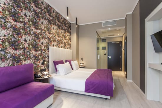 a bedroom with a bed and purple couches