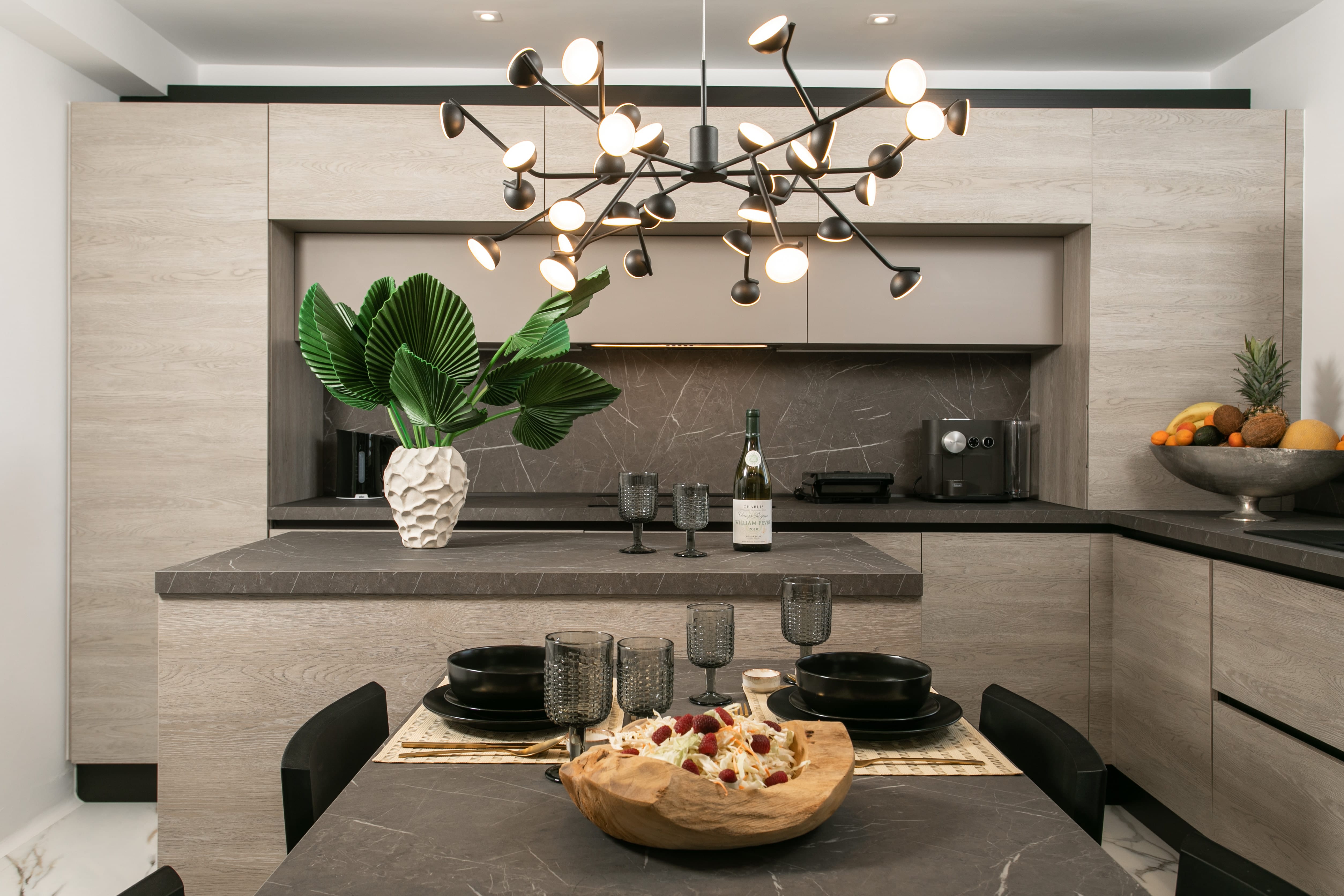 a kitchen with a large chandelier over the island