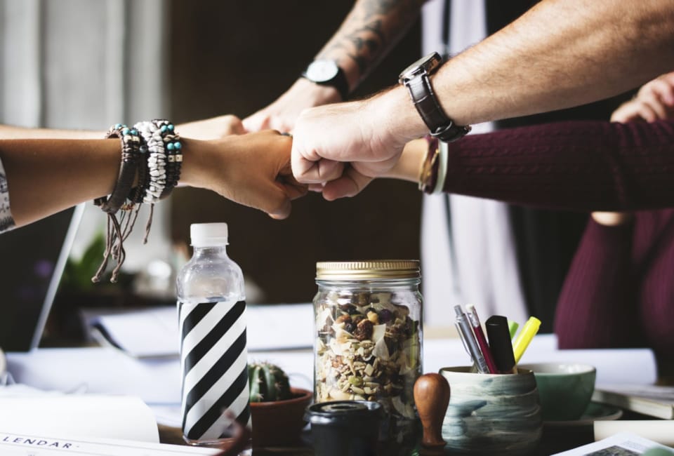 a few hands holding a jar