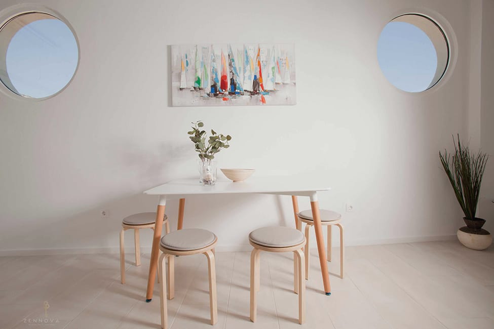 a table with stools and a vase of flowers on it